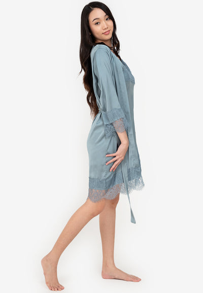 A woman wearing a slip dress in a robe blue