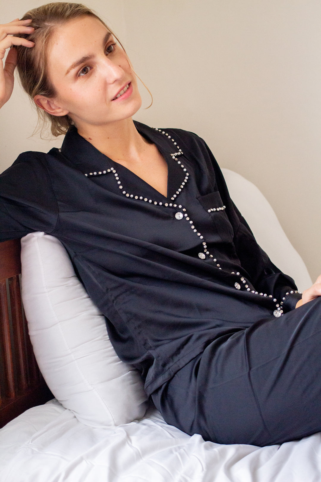 A woman wearing a silk long sleeve pajama set