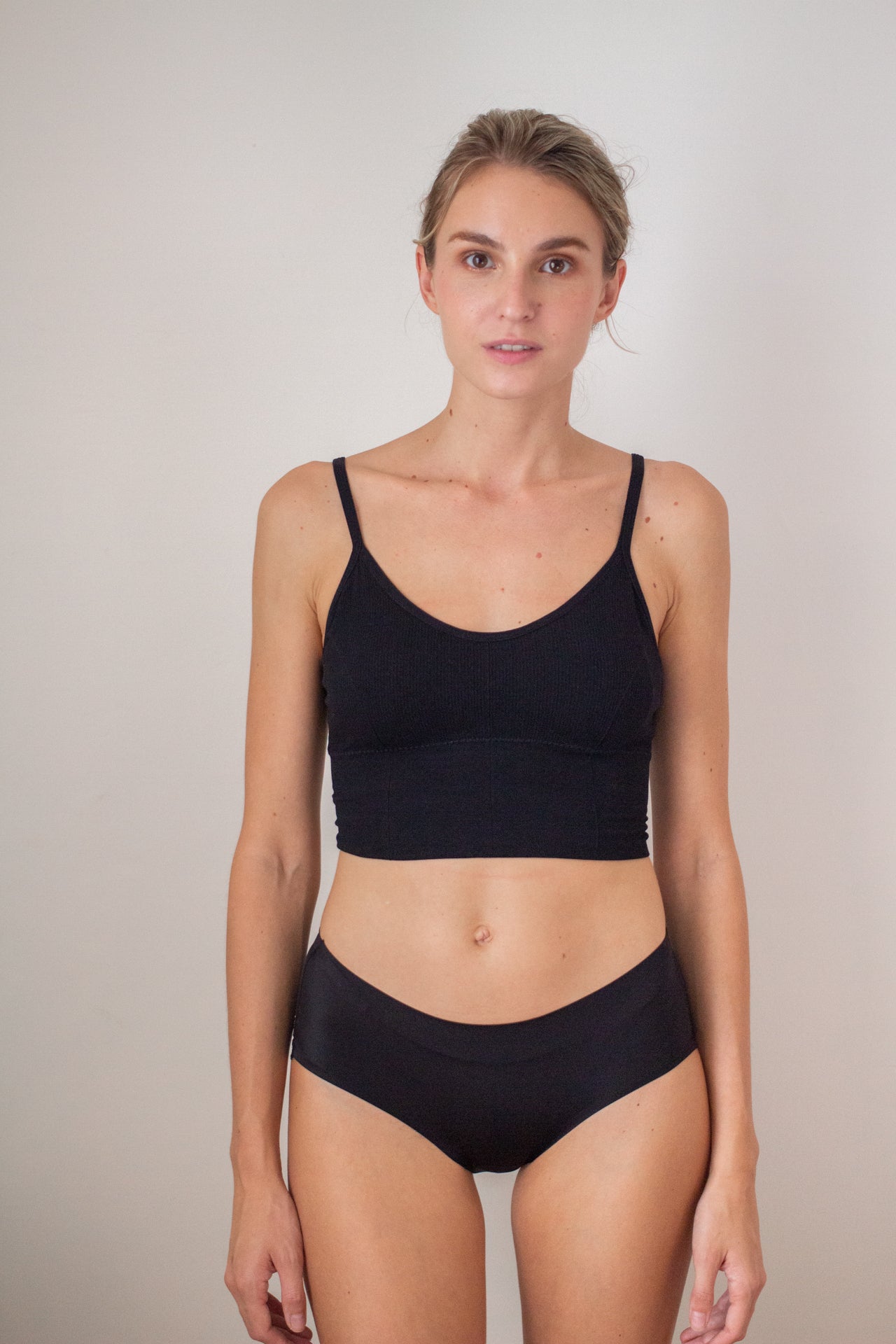woman front facing wearing a black bralette