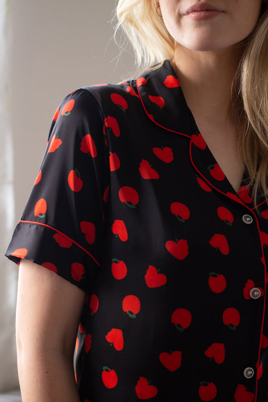 An up-close shot of a woman standing and wearing a short sleeve top