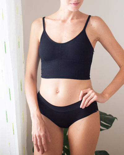 upclose photo of a woman front facing wearing a black bralette