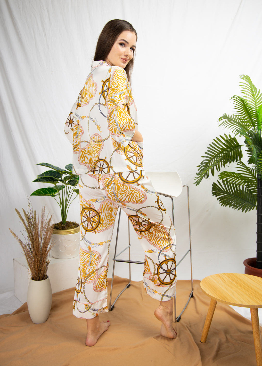 A woman sitting and wearing a silk long sleeve pajama set