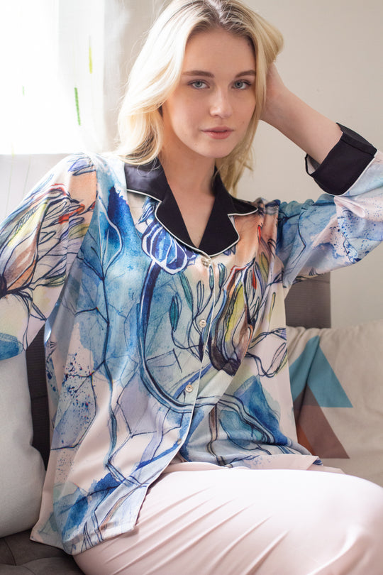 A woman sitting and wearing a silk long sleeve pajama set