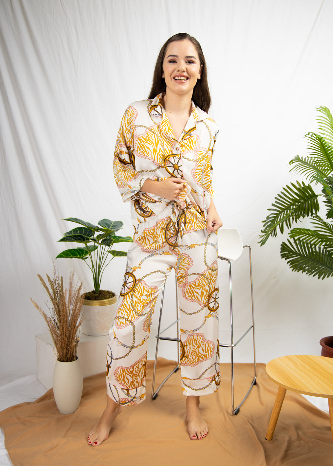 A woman sitting and wearing a silk long sleeve pajama set