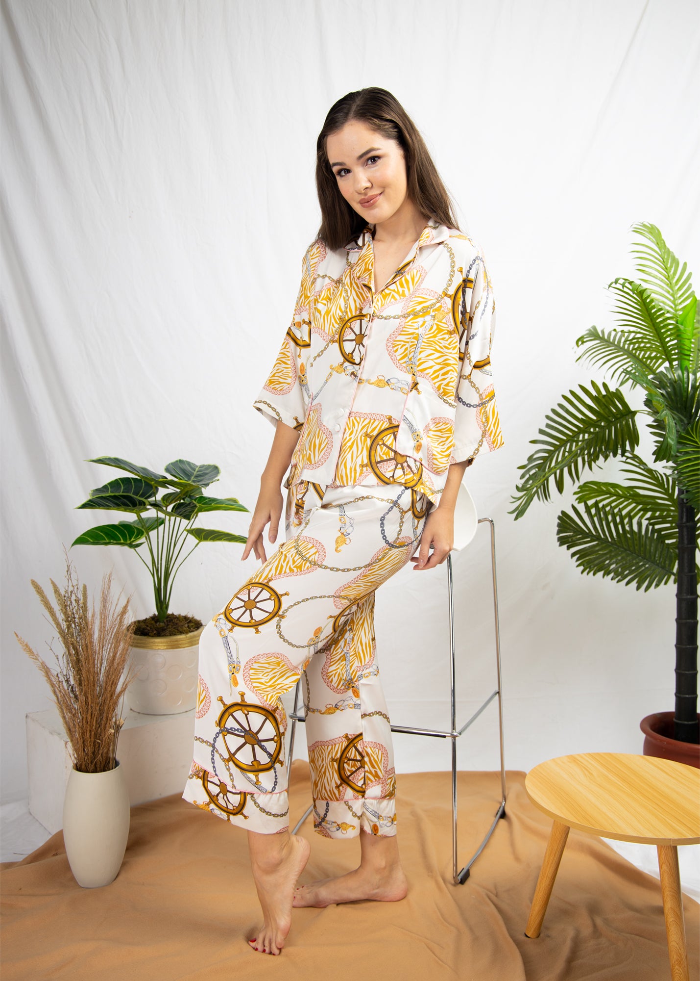 A woman sitting and wearing a silk long sleeve pajama set