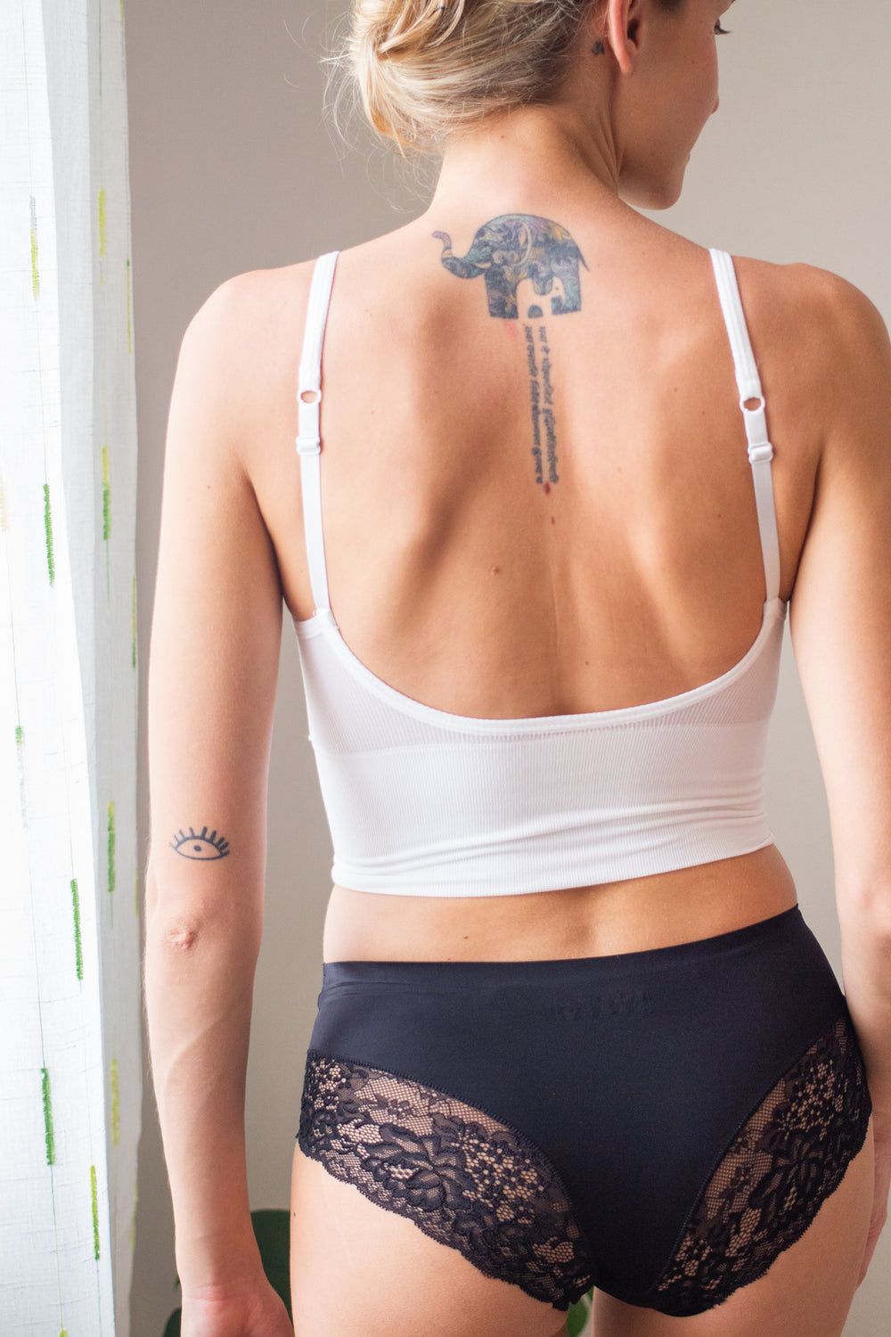 woman back facing wearing a black bralette