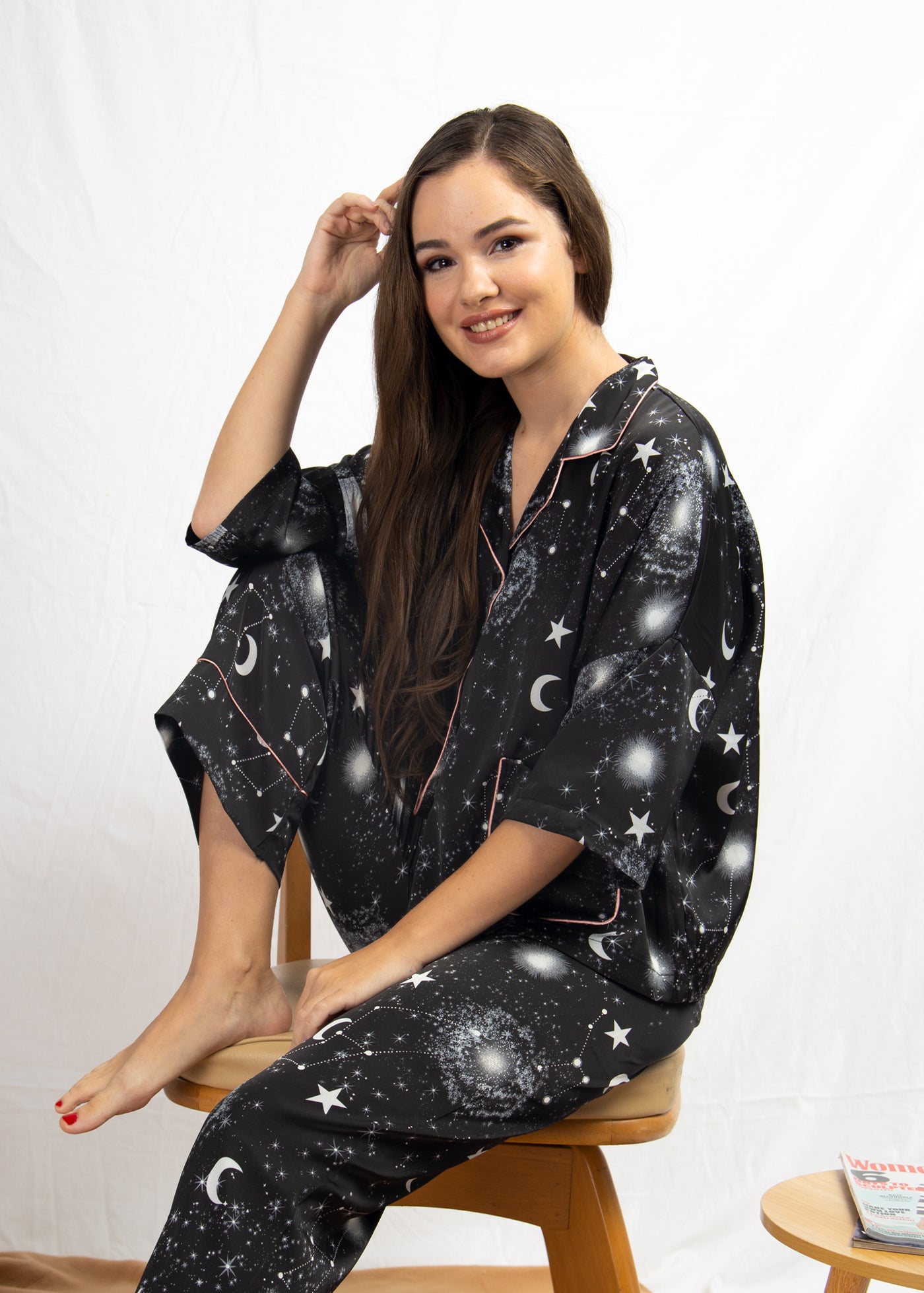 A woman sitting and wearing a long sleeve pajama set