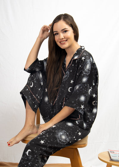 A woman sitting and wearing a long sleeve pajama set