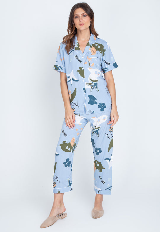 A woman standing and wearing a short sleeve floral cotton pajama set
