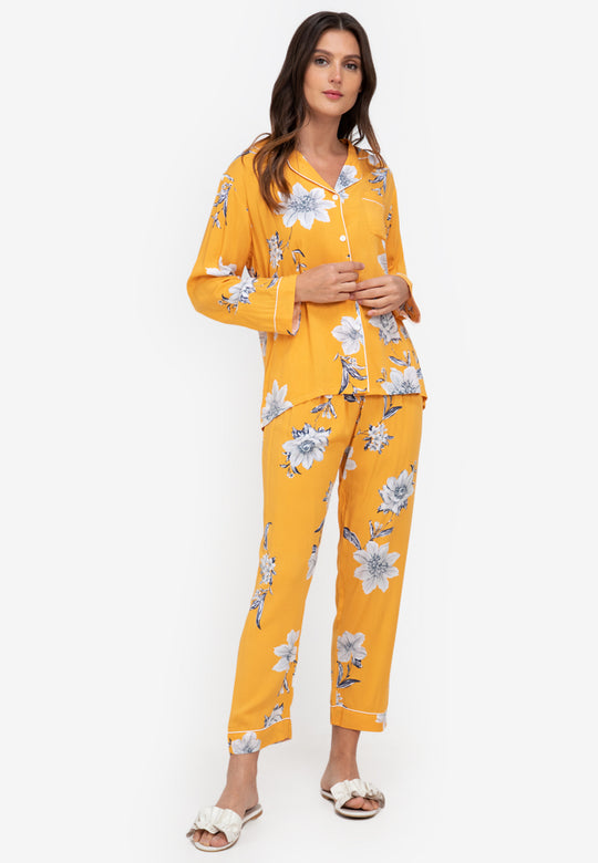 A woman standing and wearing a long sleeve floral cotton pajama set