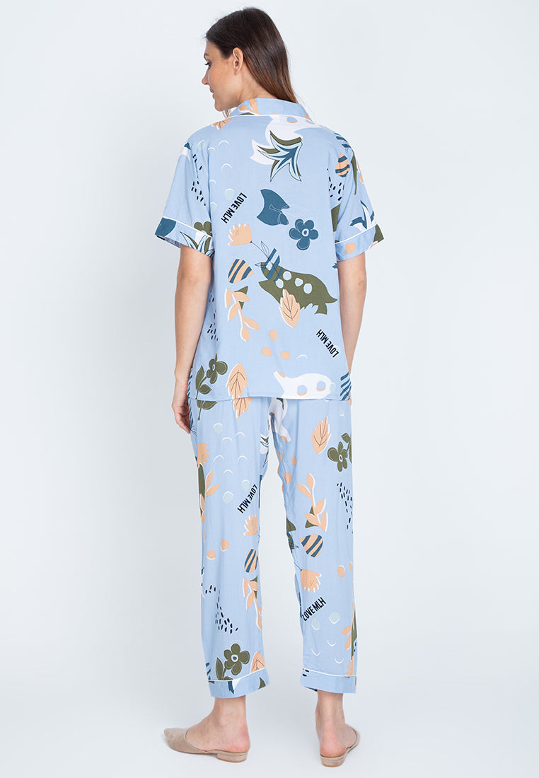 A woman standing back and wearing a short sleeve floral cotton pajama set