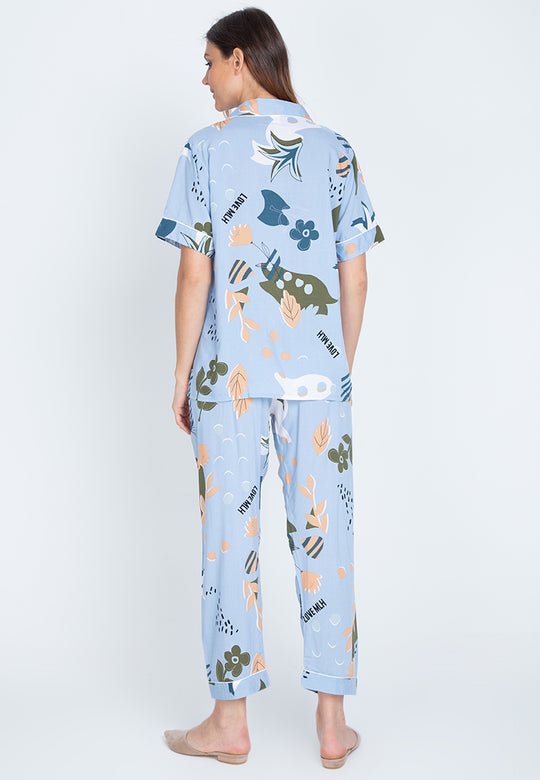 A woman standing back and wearing a short sleeve floral cotton pajama set
