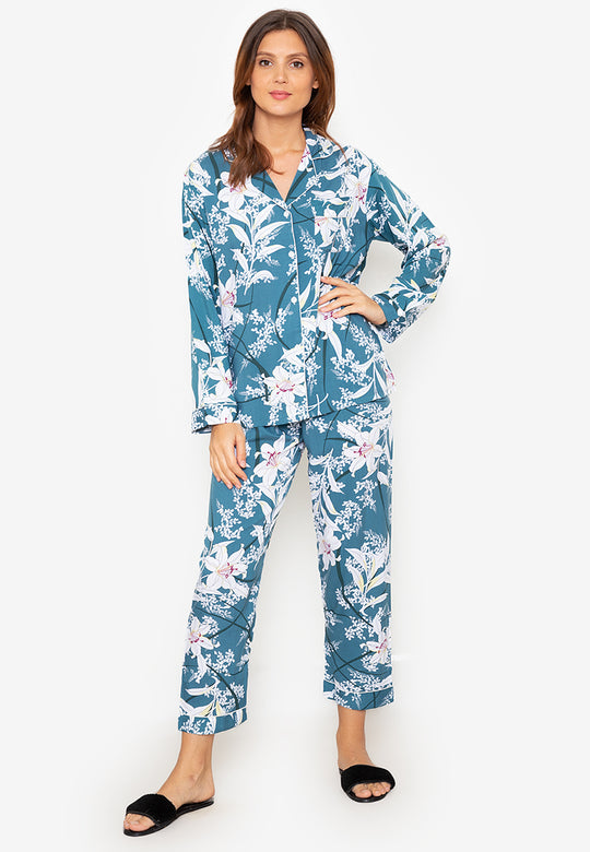 A woman standing and wearing a long sleeve pajama set