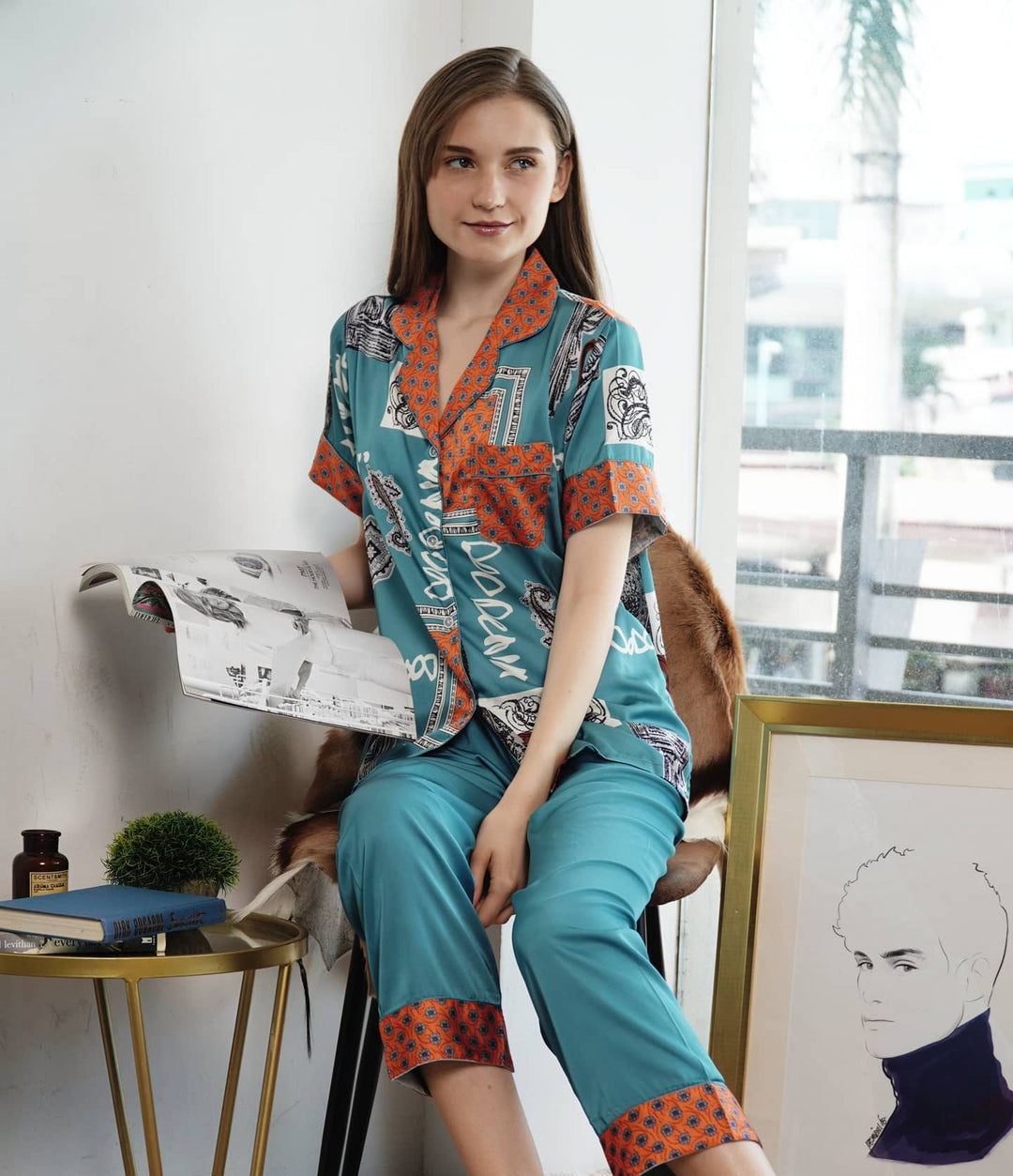 A woman standing and wearing a silk long sleeve pajama set