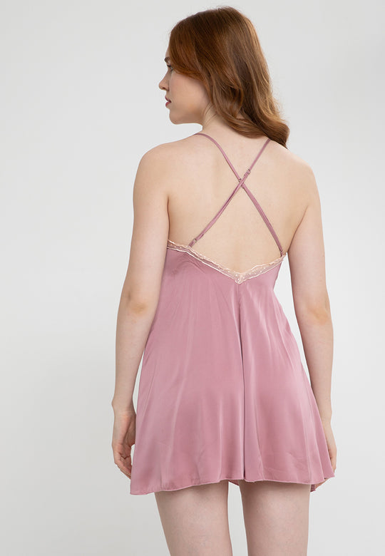 A woman standing and wearing Pink Silk slip dress