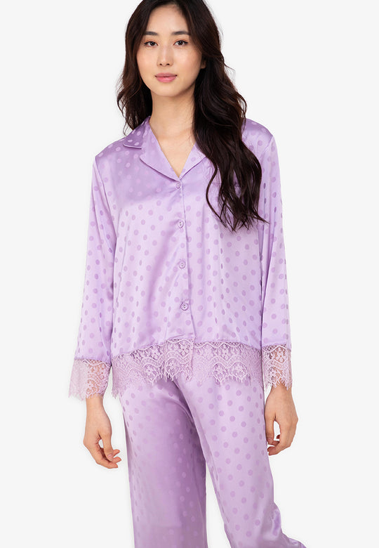 A woman wearing a silk long sleeve pajama set