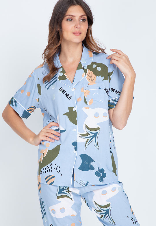 A woman standing and wearing a short sleeve floral cotton pajama set