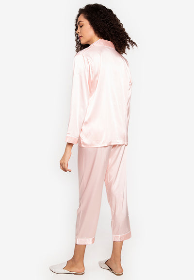 A woman wearing a silk long sleeve pajama set