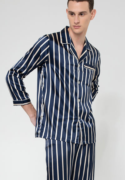 A man standing and wearing a silk pajama set