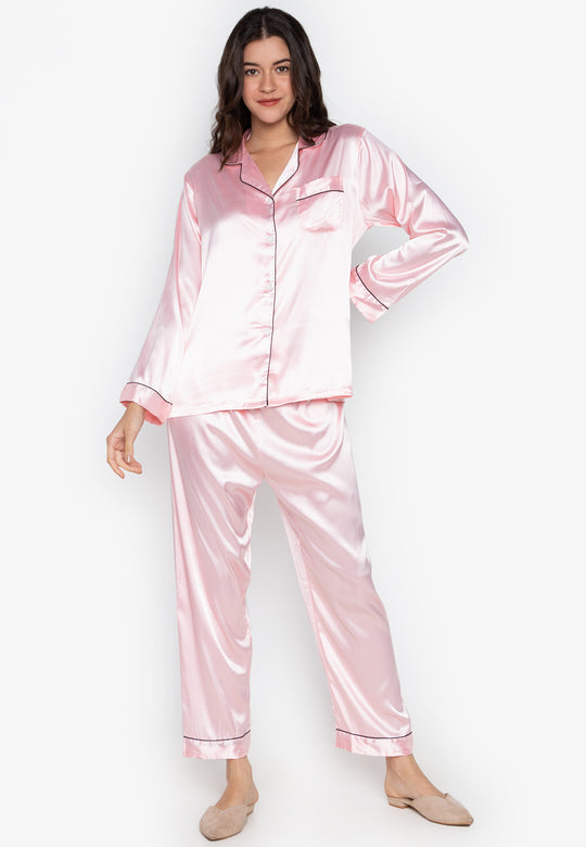 A woman wearing a silk long sleeve pajama set