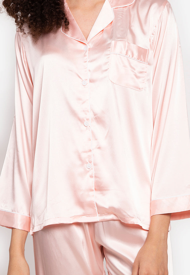 A woman wearing a silk long sleeve pajama set