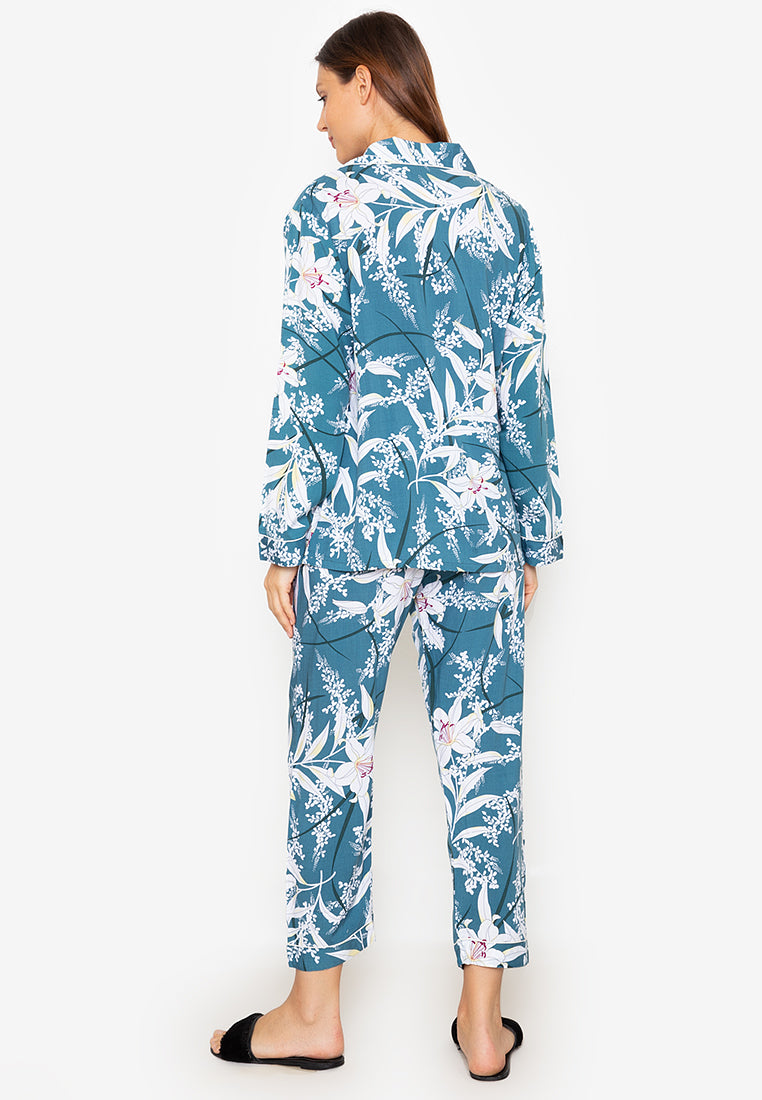 A woman standing and wearing a long sleeve pajama set