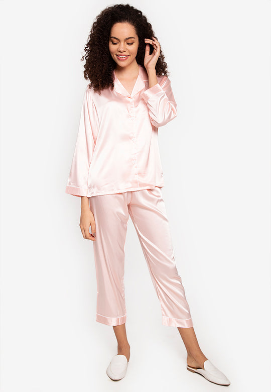 A woman wearing a silk long sleeve pajama set