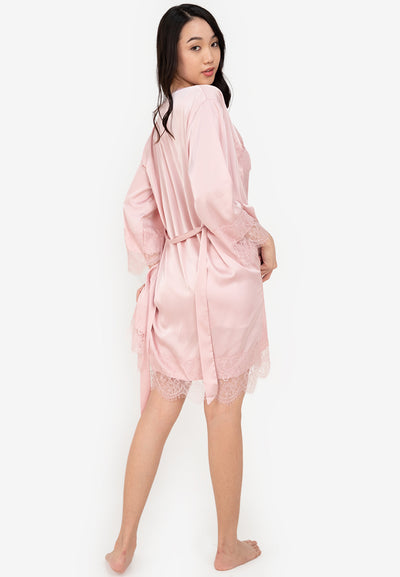 A woman wearing a slip dress in a robe pink