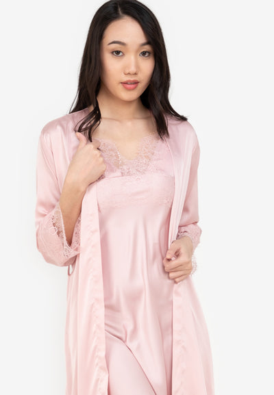 A woman wearing a slip dress in a robe pink