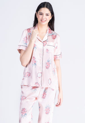 A woman standing and wearing a silk short sleeve pajama set