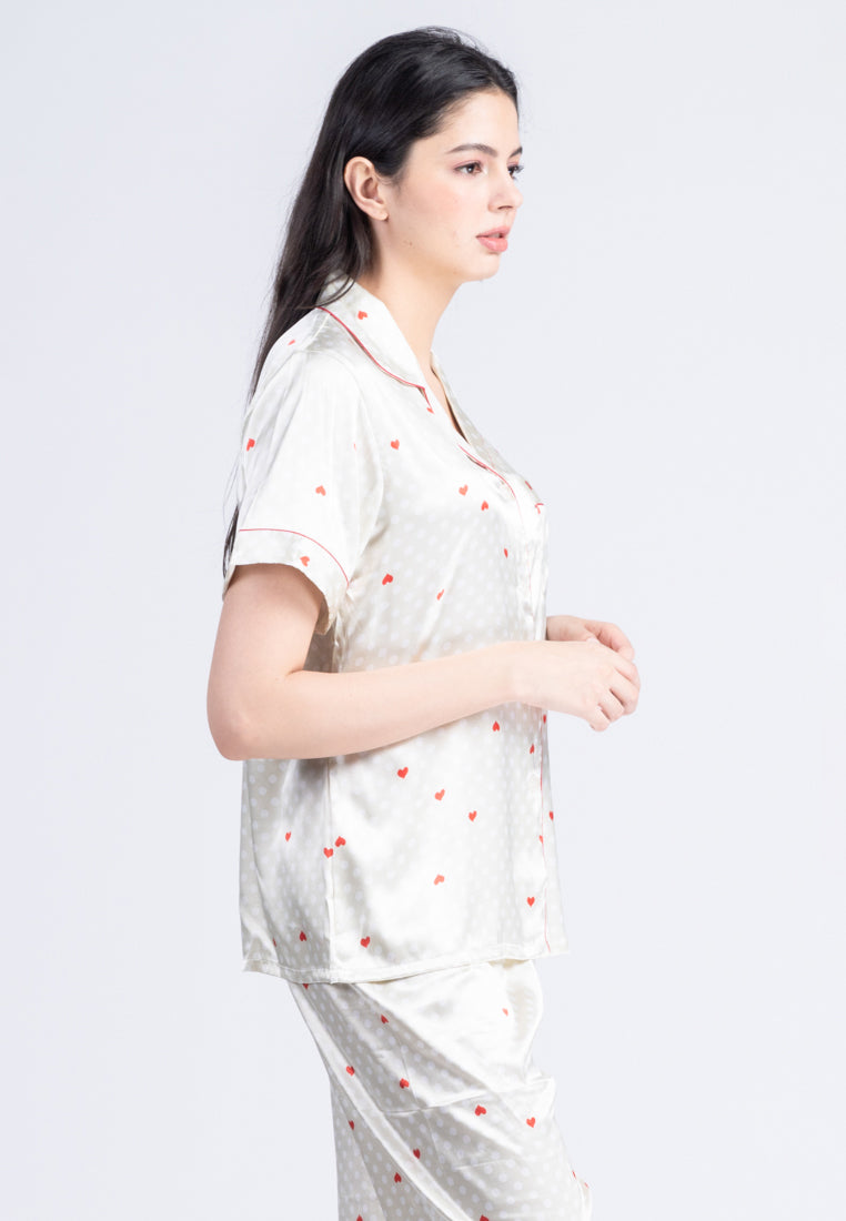 A woman standing and wearing a silk short sleeve pajama set