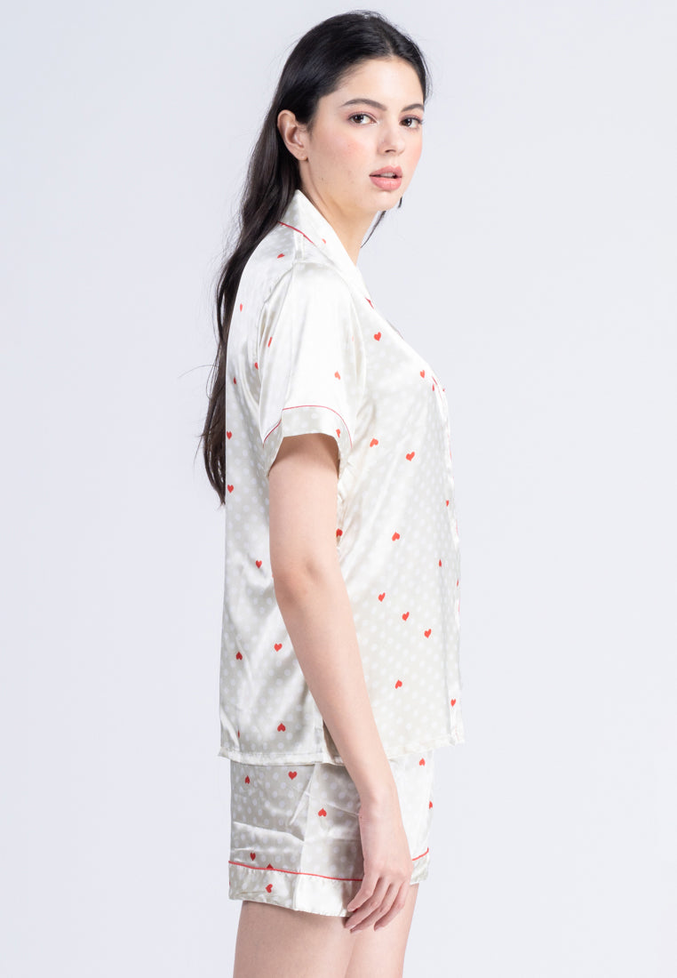 A woman standing and wearing a silk short sleeve short set