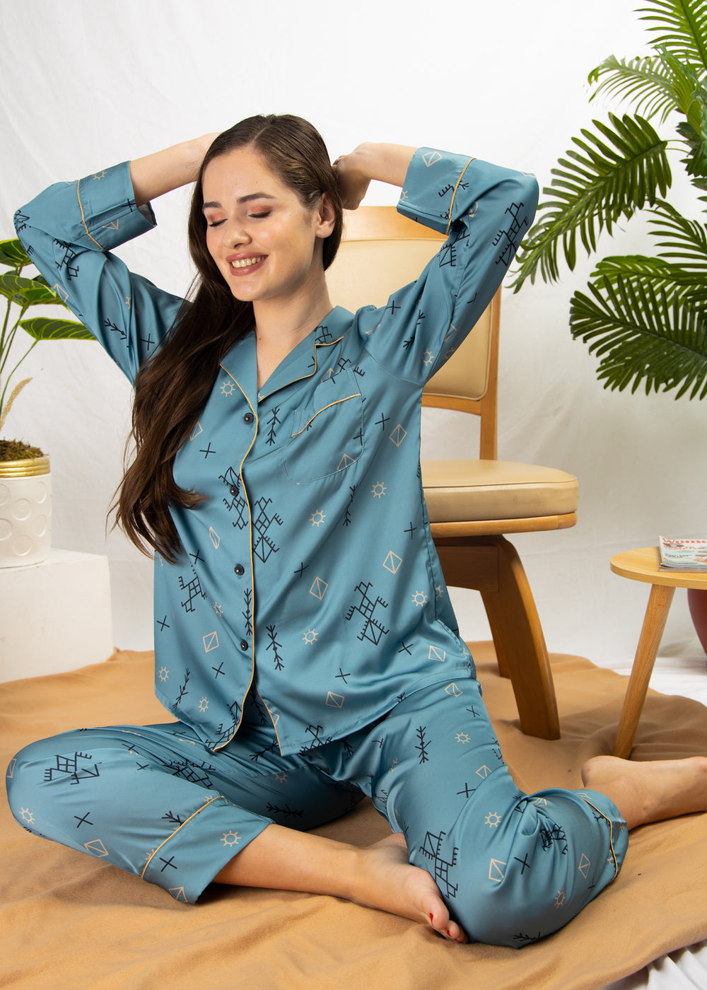 A woman sitting and wearing a long sleeve pajama set