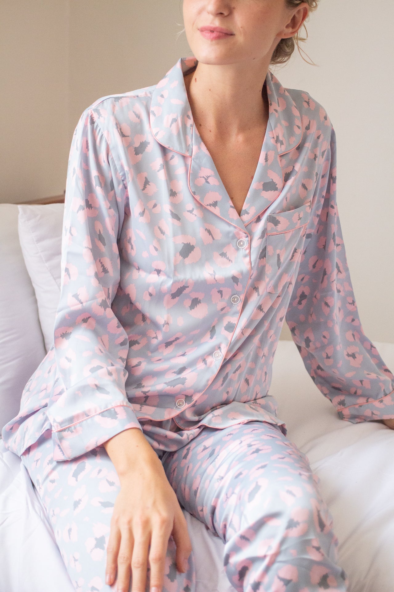 A woman sitting on the bed wearing long sleeve pajama set