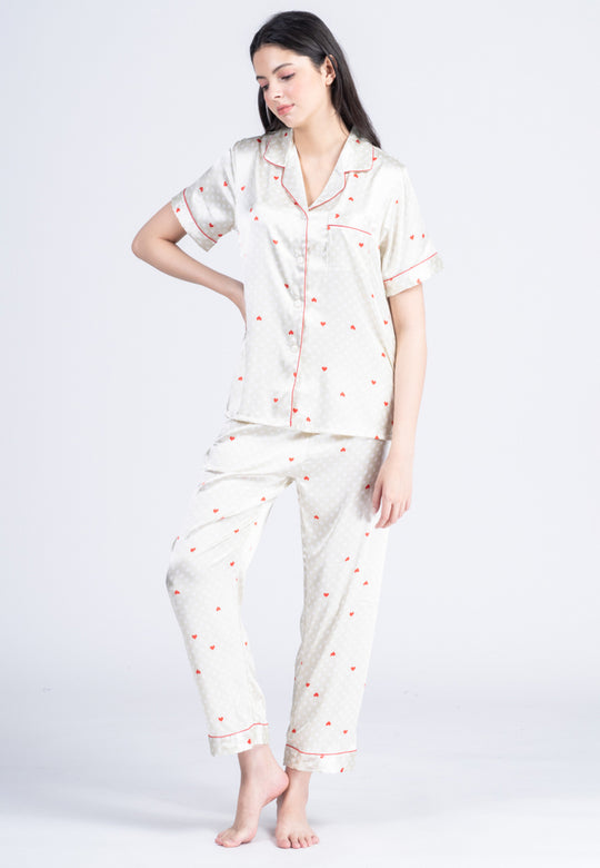 A woman standing and wearing a silk short sleeve pajama set