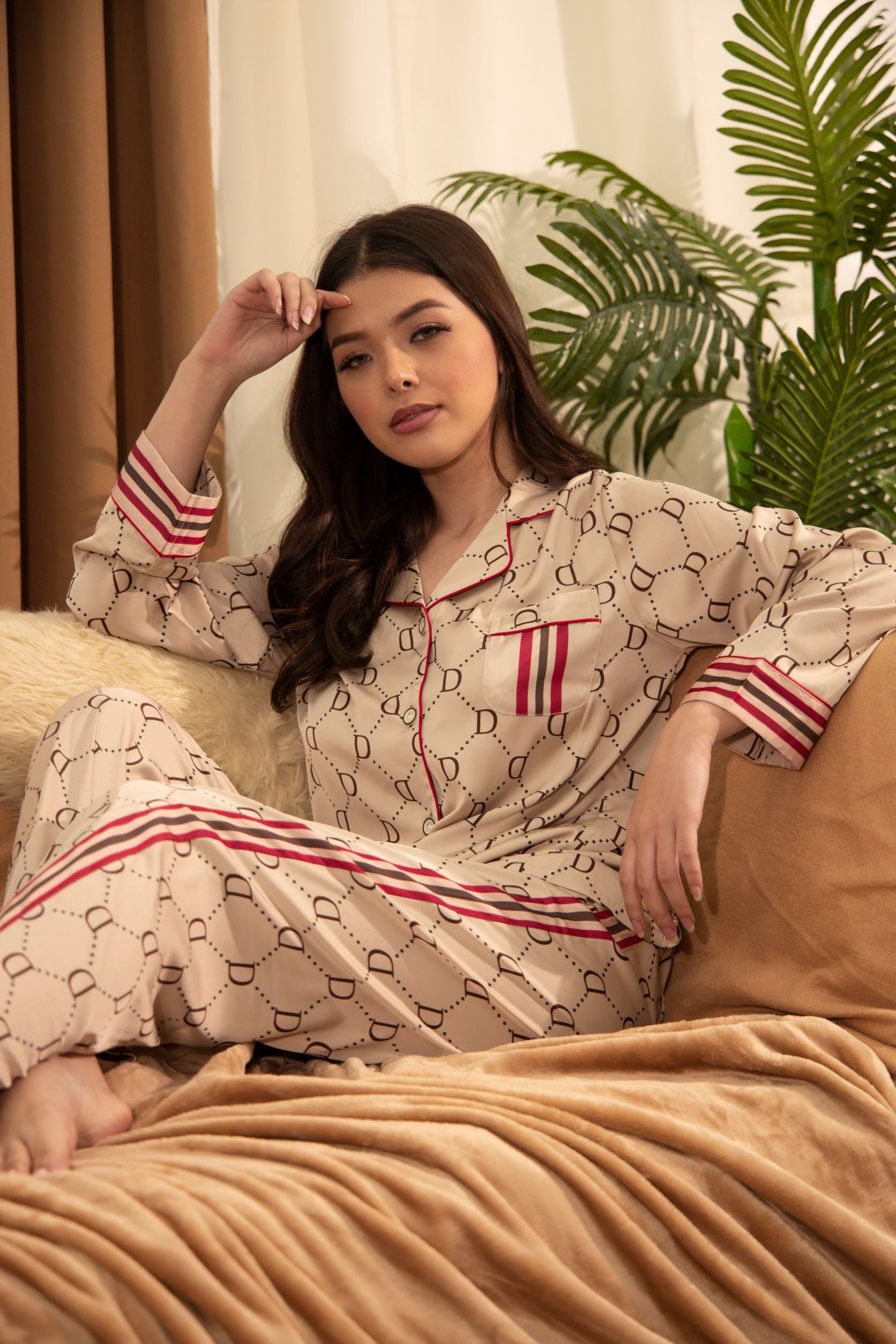 A woman standing and wearing a collared silk long sleeve pajama set