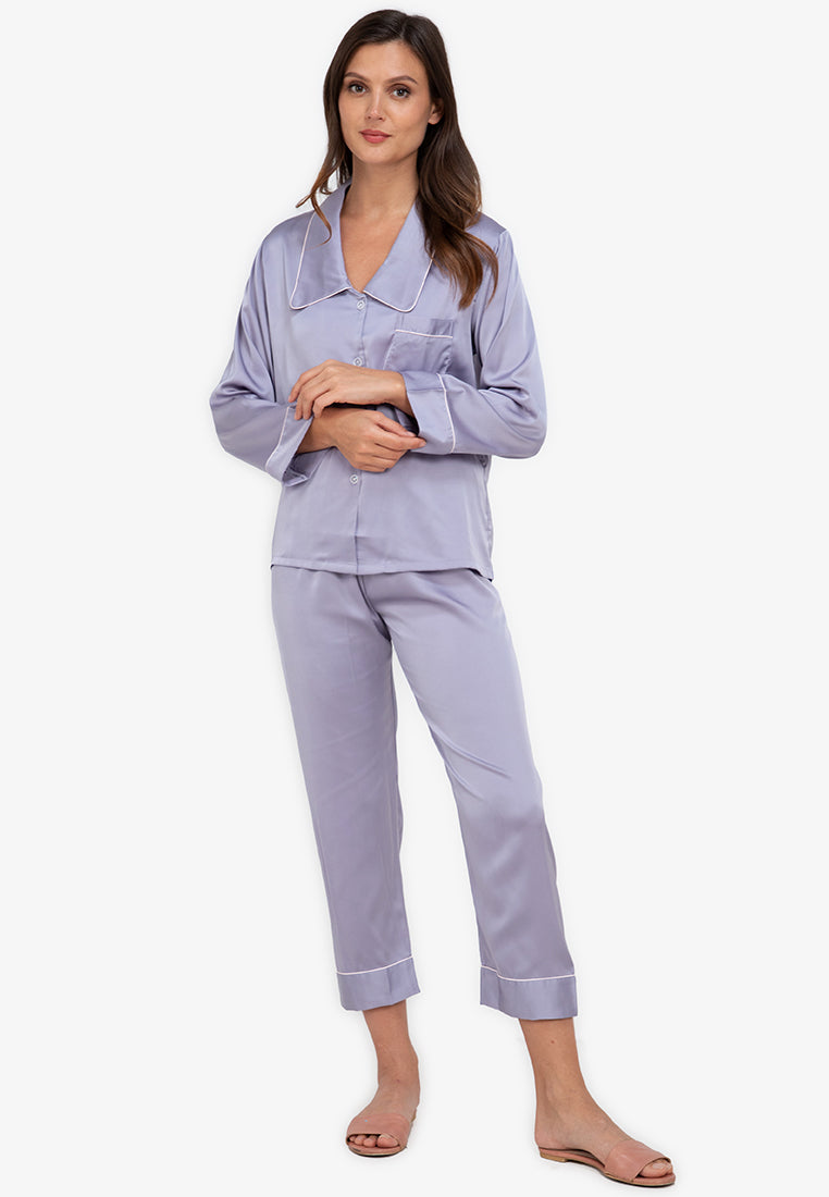 A woman standing and wearing silk long sleeve pajama set