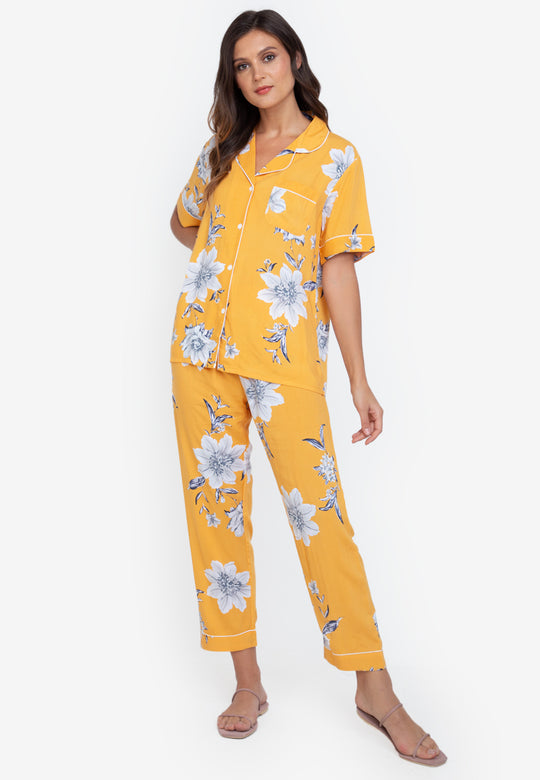 A woman standing and wearing a short sleeve floral cotton pajama set