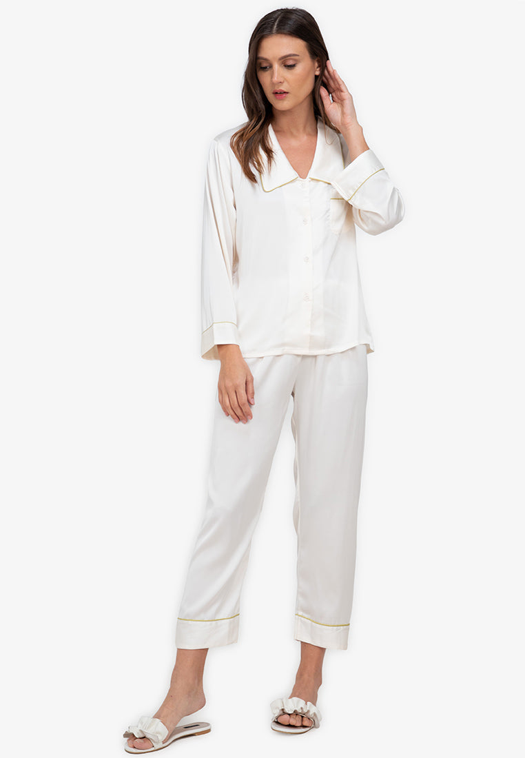 A woman standing and wearing silk long sleeve pajama set